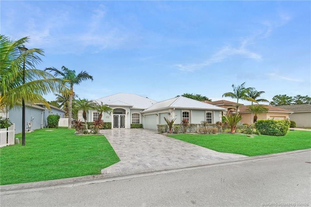 439 Northwest Sunflower Place Stuart, FL 34994 - Photo 2 of 68 a front view of a house with a garden and yard