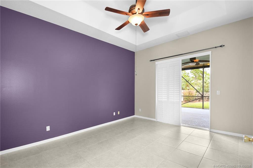 439 Northwest Sunflower Place Stuart, FL 34994 - Photo 23 of 68 an empty room with windows and a ceiling fan