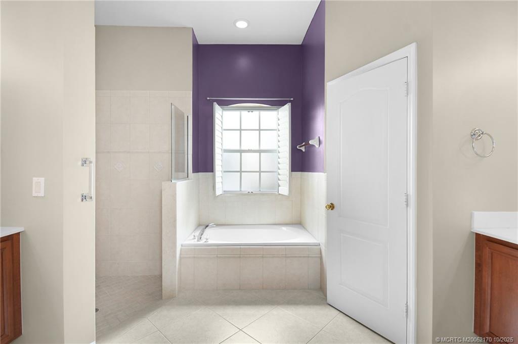 439 Northwest Sunflower Place Stuart, FL 34994 - Photo 26 of 68 a bathroom with a bathtub and window