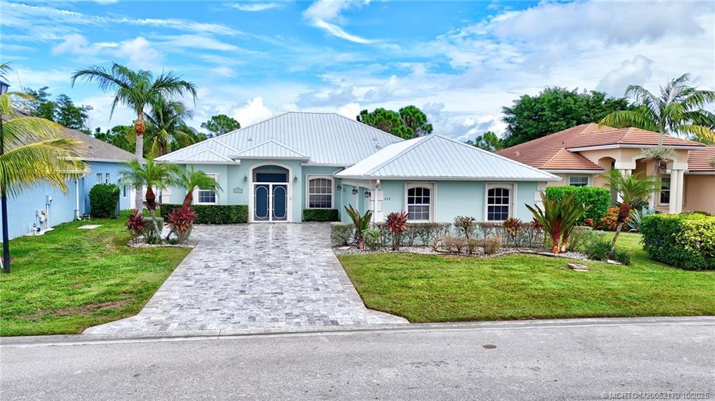 439 Northwest Sunflower Place Stuart, FL 34994 - Photo 38 of 68 a front view of a house with a garden