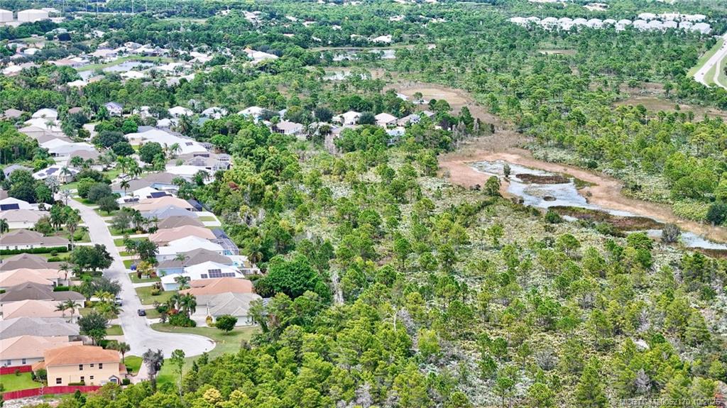 439 Northwest Sunflower Place Stuart, FL 34994 - Photo 60 of 68 an aerial view of residential houses with outdoor space and trees