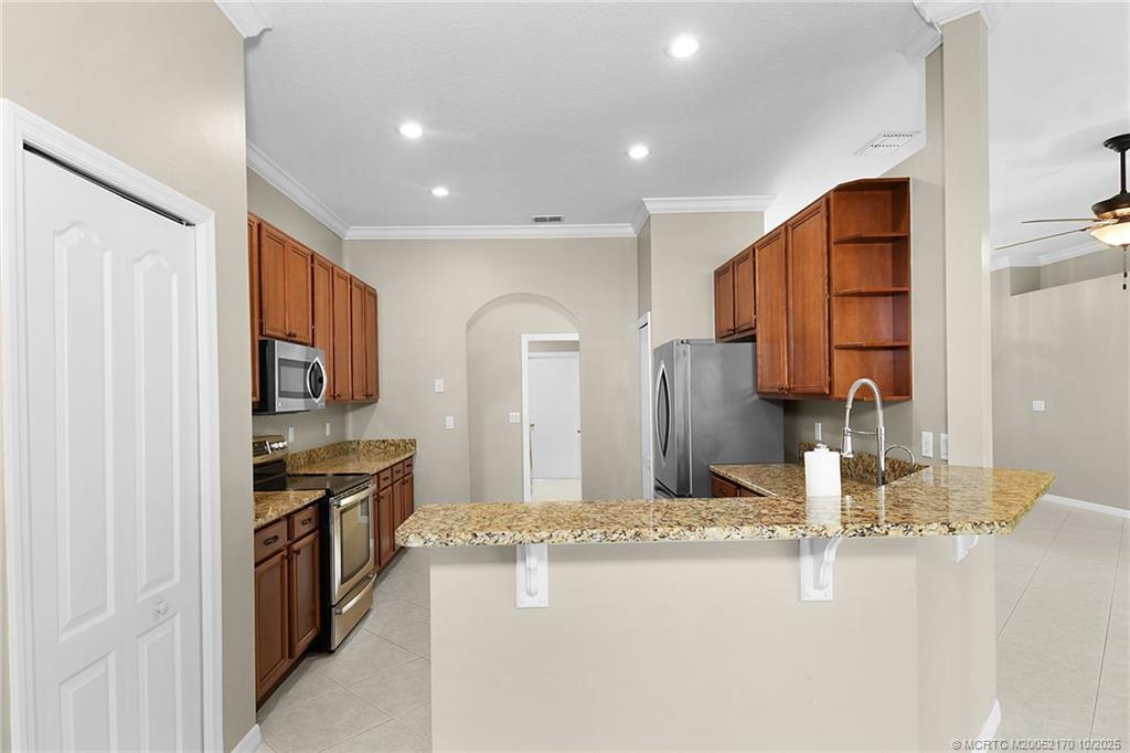 439 Northwest Sunflower Place Stuart, FL 34994 - Photo 7 of 68 a kitchen with stainless steel appliances granite countertop a sink and cabinets