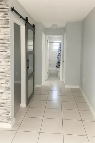 a view of a hallway to rooms and bathroom