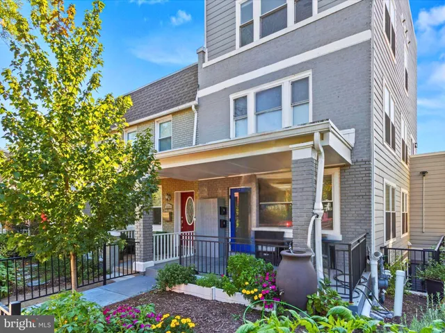 a view of a brick building plants and large tree