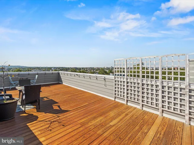 a view of roof deck with wooden floor and city view