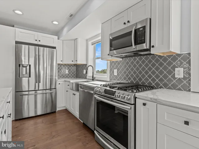 a kitchen with stainless steel appliances granite countertop a stove microwave refrigerator and cabinets