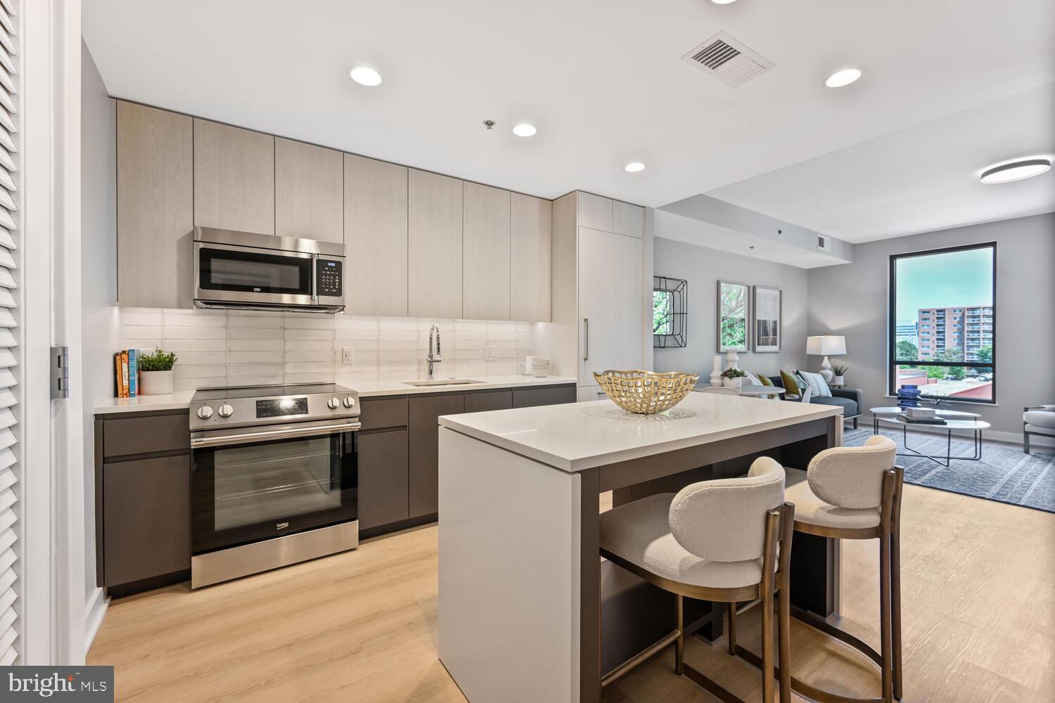 950 3rd Street Northwest, Unit 901 Washington, DC 20001 - Photo 24 of 30 a kitchen with kitchen island granite countertop a sink and stainless steel appliances