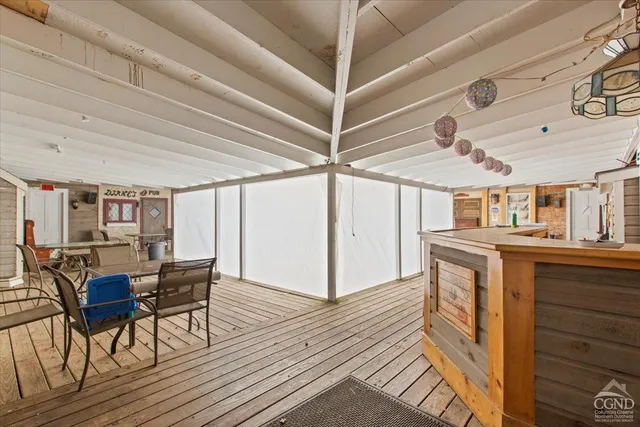 a dining room with wooden floor a chandelier a wooden table and chairs