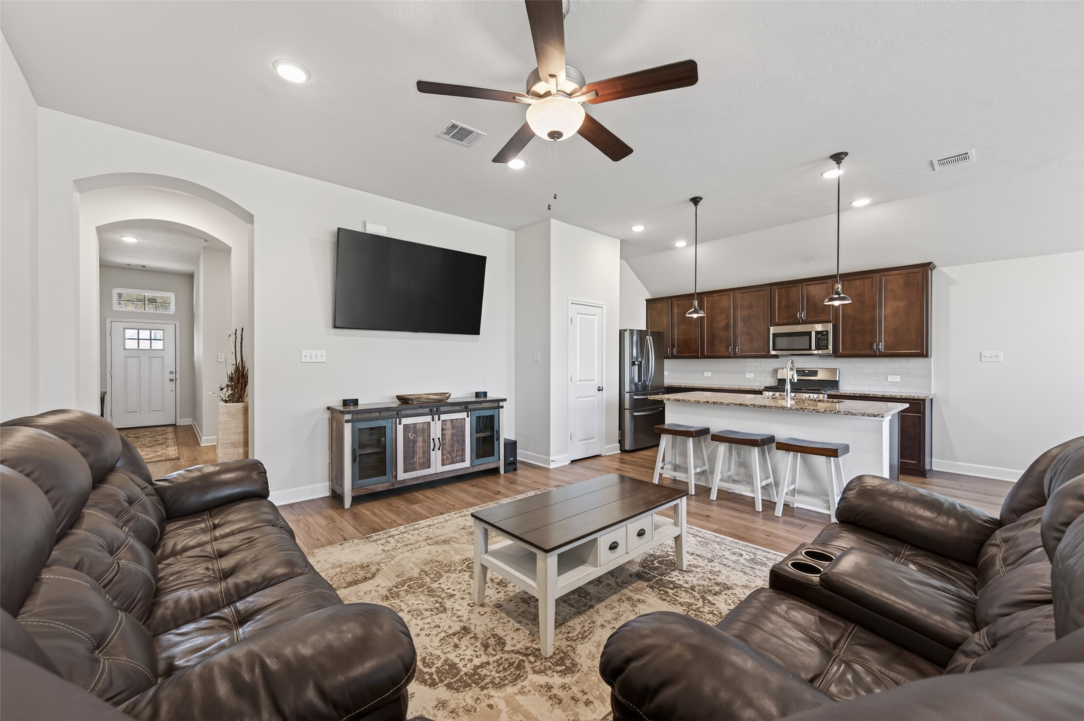 917 Farm Path Brenham, TX 77833 - Photo 10 of 43 a living room with furniture kitchen view and a flat screen tv