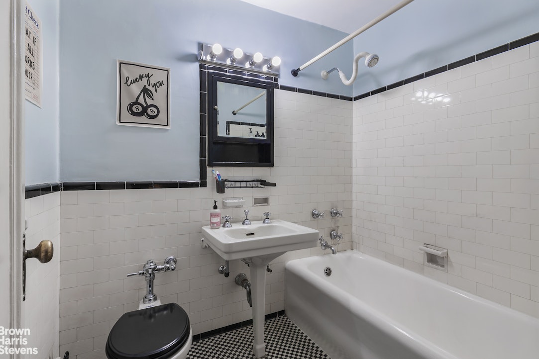 433 West 34th Street, Unit 5M Manhattan, NY 10001 - Photo 5 of 13 a bathroom with a sink a toilet and shower