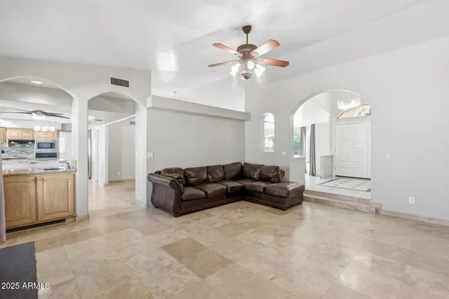 a view of an empty room and a chandelier fan