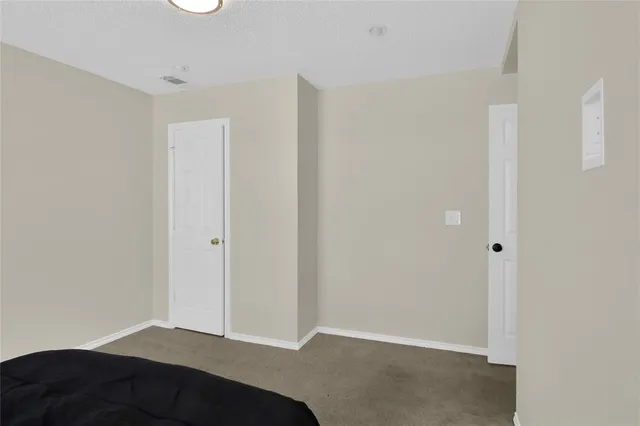 a bedroom with a bed a large window and a chandelier