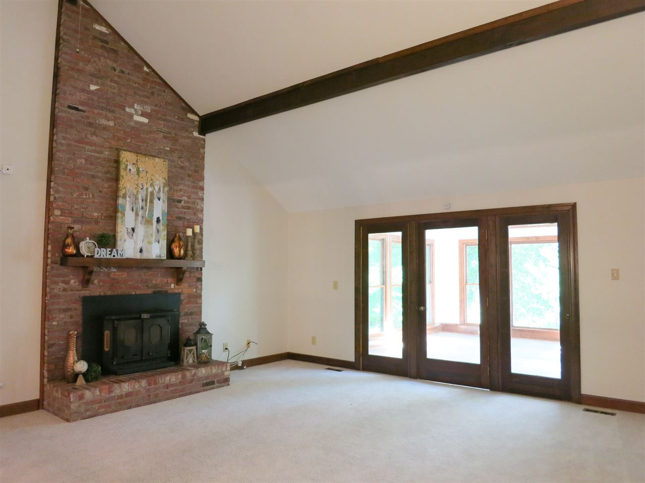 809 Ivanhoe Drive Raleigh, NC 27615 - Photo 4 of 30 Big vaulted Living Rm w/FP (wood stove insert), ceiling beams, CF & neutral carpet accesses vaulted Sun Rm. Living Room