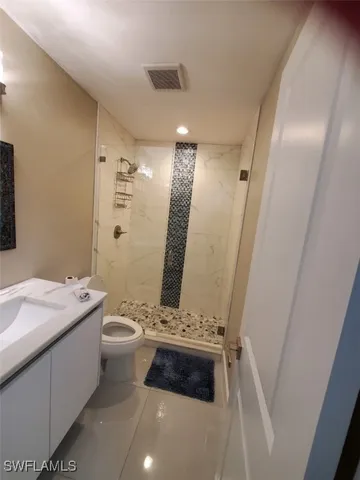 a bathroom with a double vanity sink a toilet and a mirror