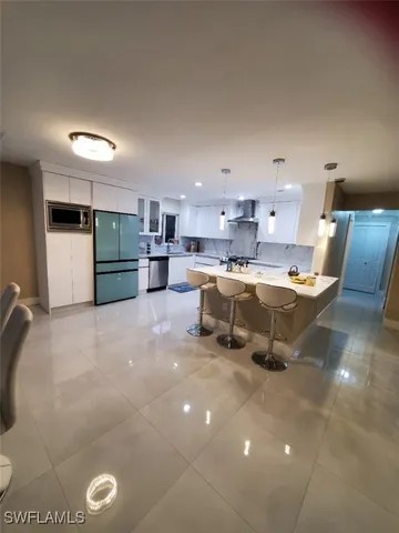 a large kitchen with a large counter top stainless steel appliances and cabinets