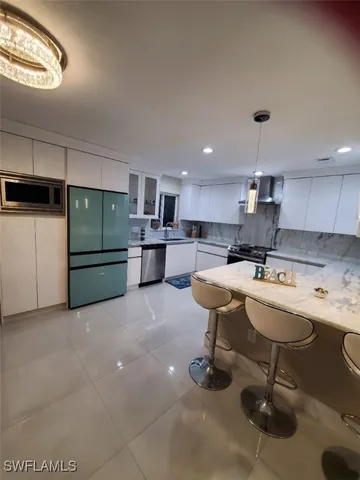 a kitchen with stainless steel appliances granite countertop a sink and a refrigerator