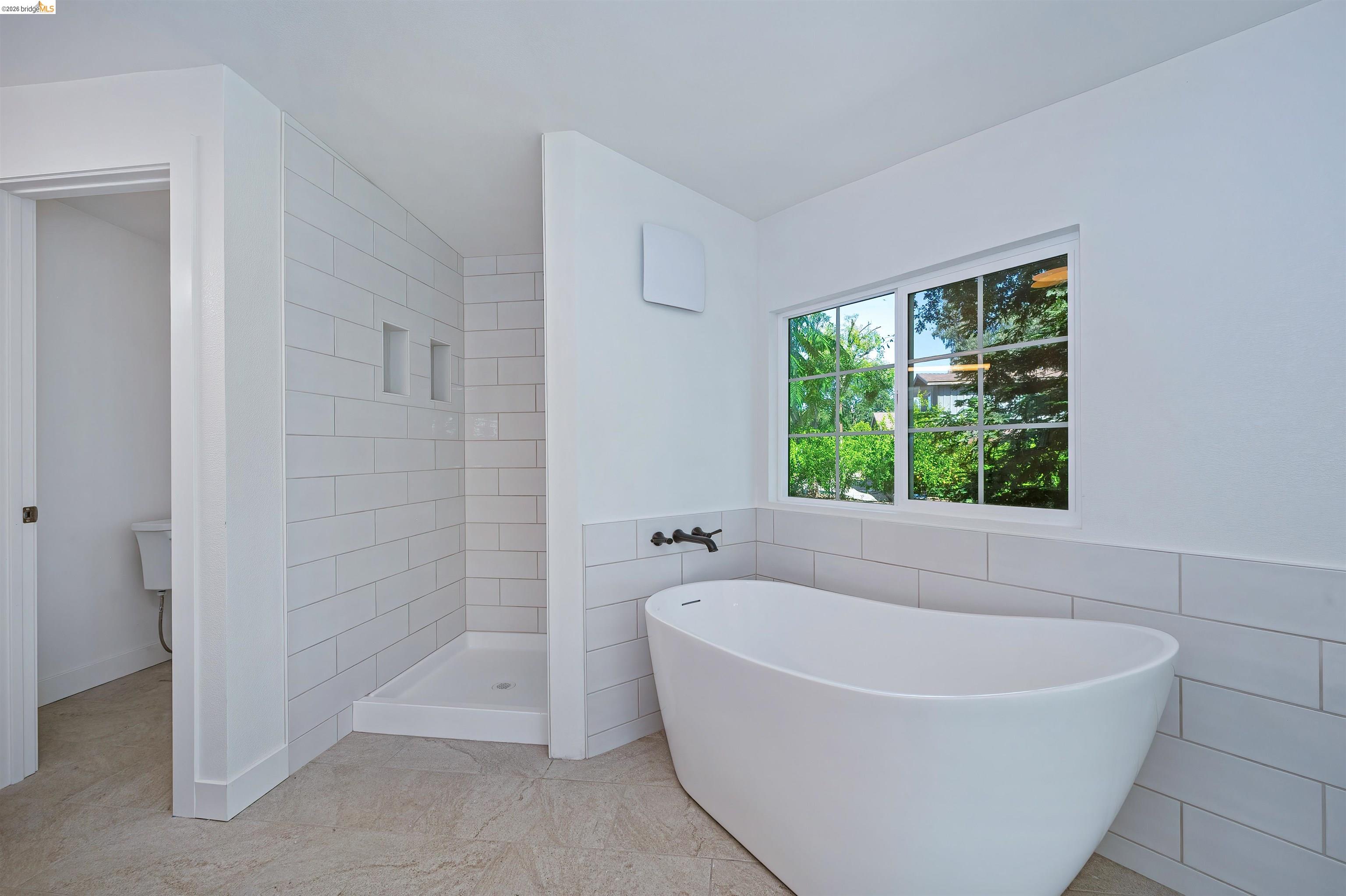 10474 Sheldon Road Elk Grove, CA 95624 - Photo 34 of 83 Freestanding soaking tub with wall-mounted matte black fixtures, set against a tiled wall