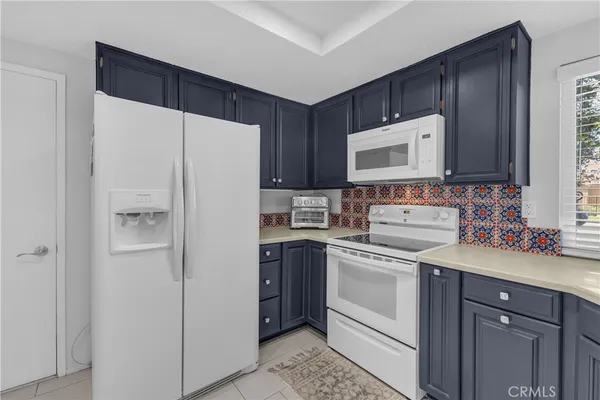 a kitchen with a refrigerator sink and cabinets