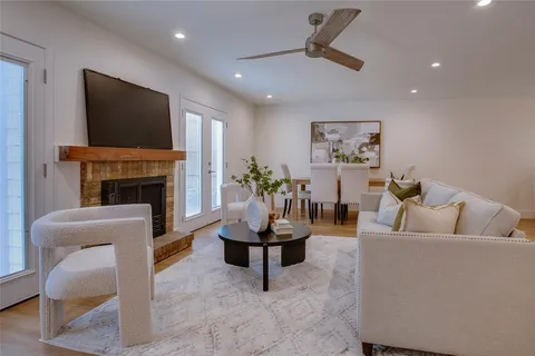 a living room with furniture a chandelier and a dining table