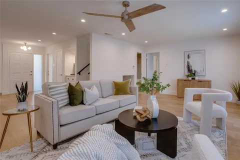 a living room with fireplace furniture and a chandelier
