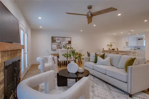 a living room with furniture a wooden floor and a flat screen tv
