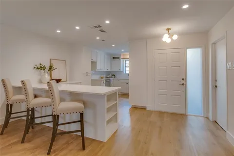 a large white kitchen with lots of counter space and furniture