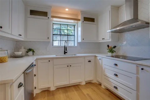 a kitchen with white cabinets and sink