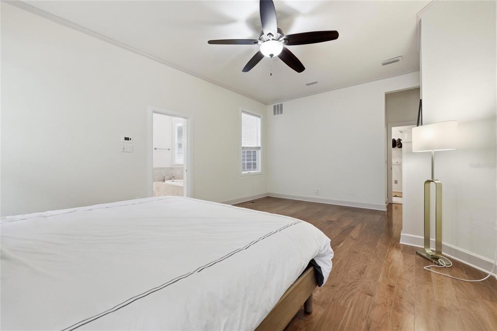 9255 Southwest 29 Avenue Gainesville, FL 32608 - Photo 25 of 79 a bedroom with a bed ceiling fan and a wooden floor