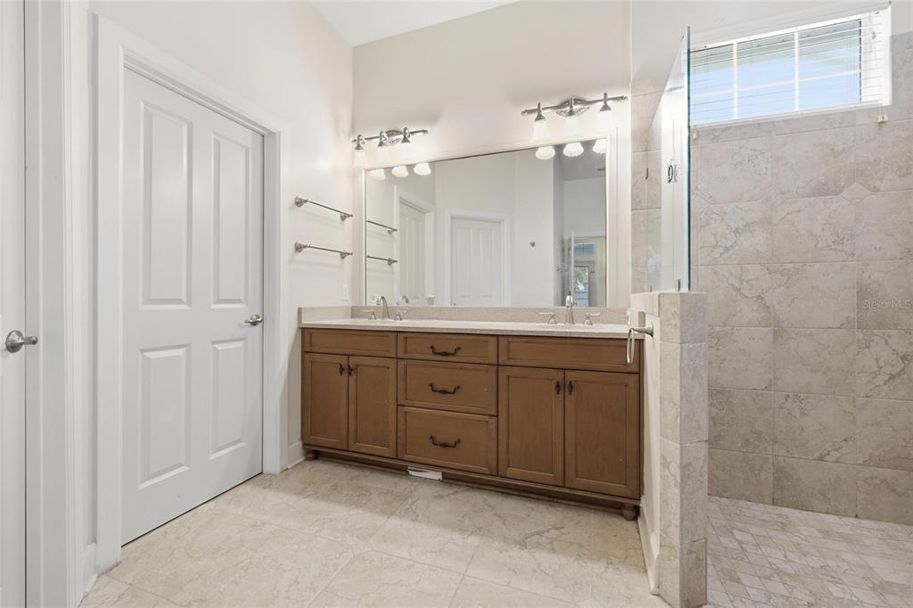 9255 Southwest 29 Avenue Gainesville, FL 32608 - Photo 31 of 79 a spacious bathroom with a granite countertop sink a mirror and a shower