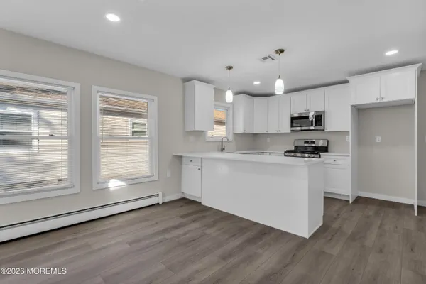 a kitchen with granite countertop a stove a sink and a refrigerator