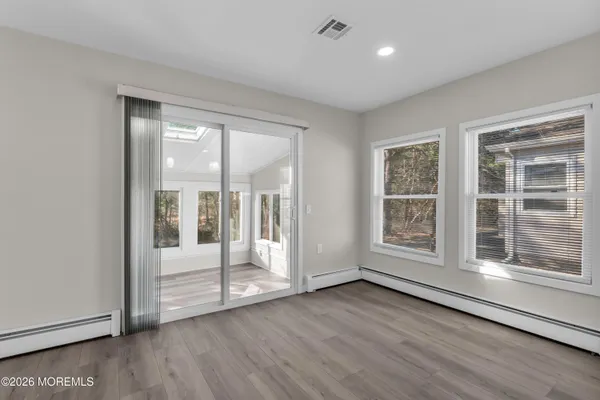 an empty room with wooden floor and windows