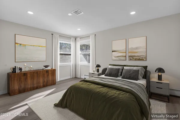 a bedroom with a large bed and a flat tv screen