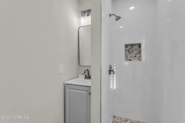 a bathroom with a sink a toilet and shower
