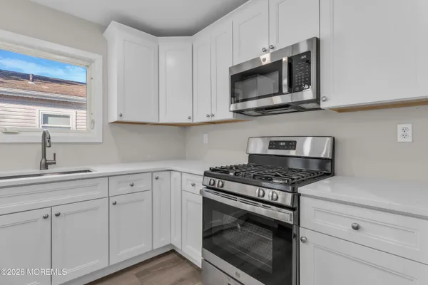 a kitchen with white cabinets and stainless steel appliances