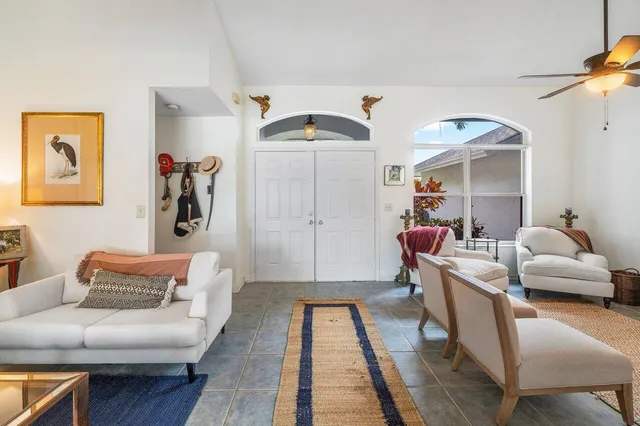 a living room with furniture a large window and a chandelier