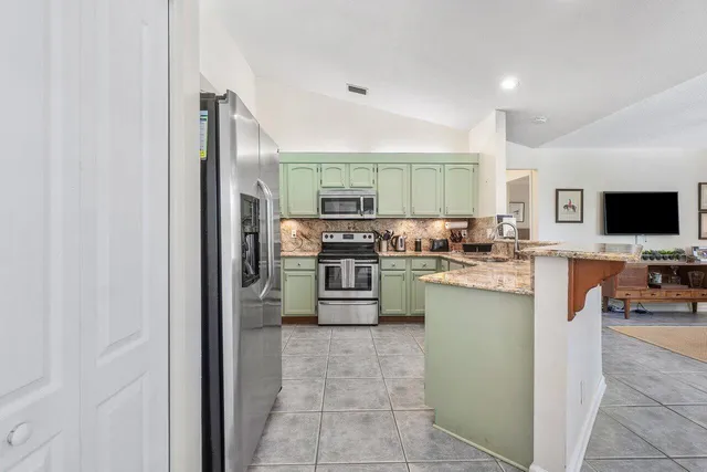 a kitchen with a sink and chairs