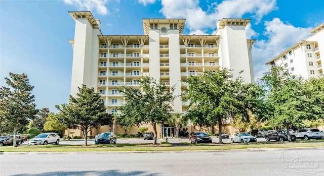 a view of building with cars parked across