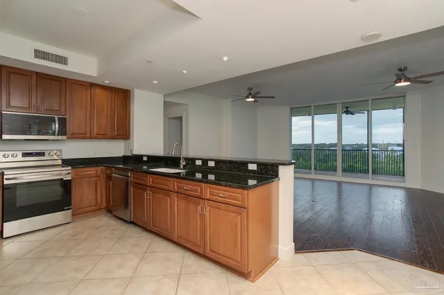 a view of kitchen with stainless steel appliances granite countertop cabinets and wooden floor