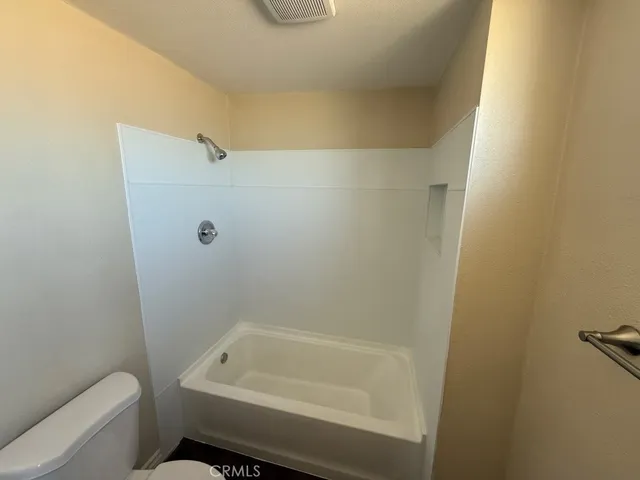 a bathroom with a toilet and bathtub
