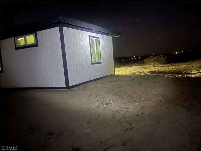 a view of an empty room with kitchen and a window