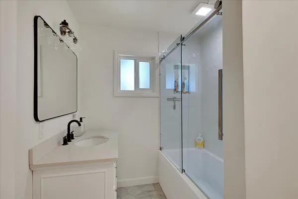 a kitchen with stainless steel appliances a stove and white cabinets