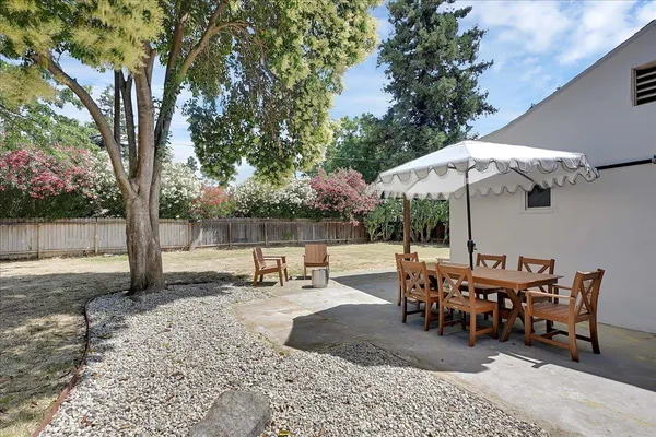 a view of a house with backyard and a trees