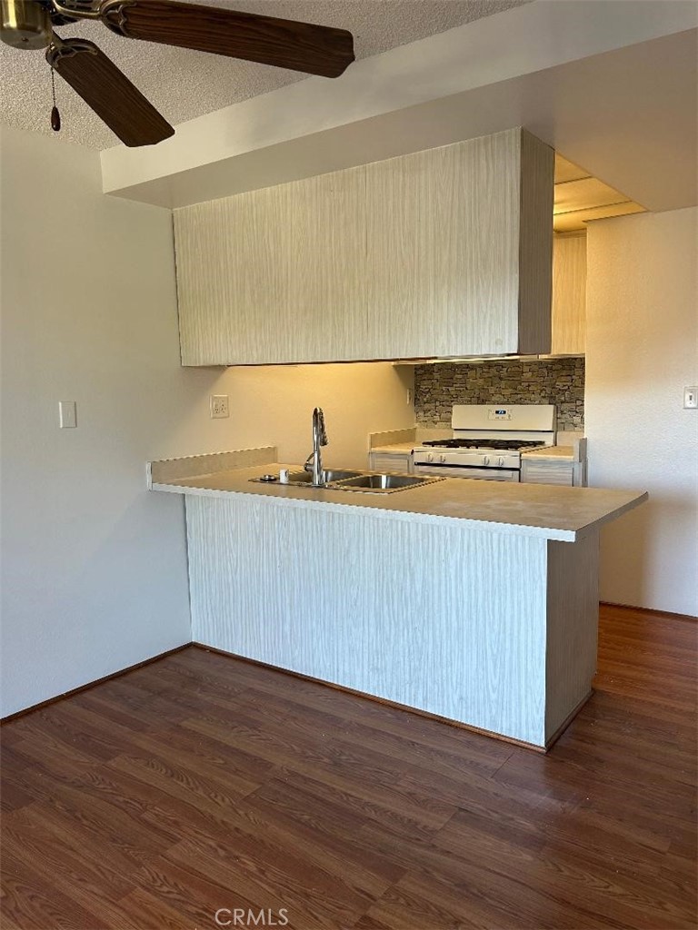 2255 Cahuilla Street, Unit 90 Colton, CA 92324 - Photo 7 of 12 a kitchen with wooden floors and a sink