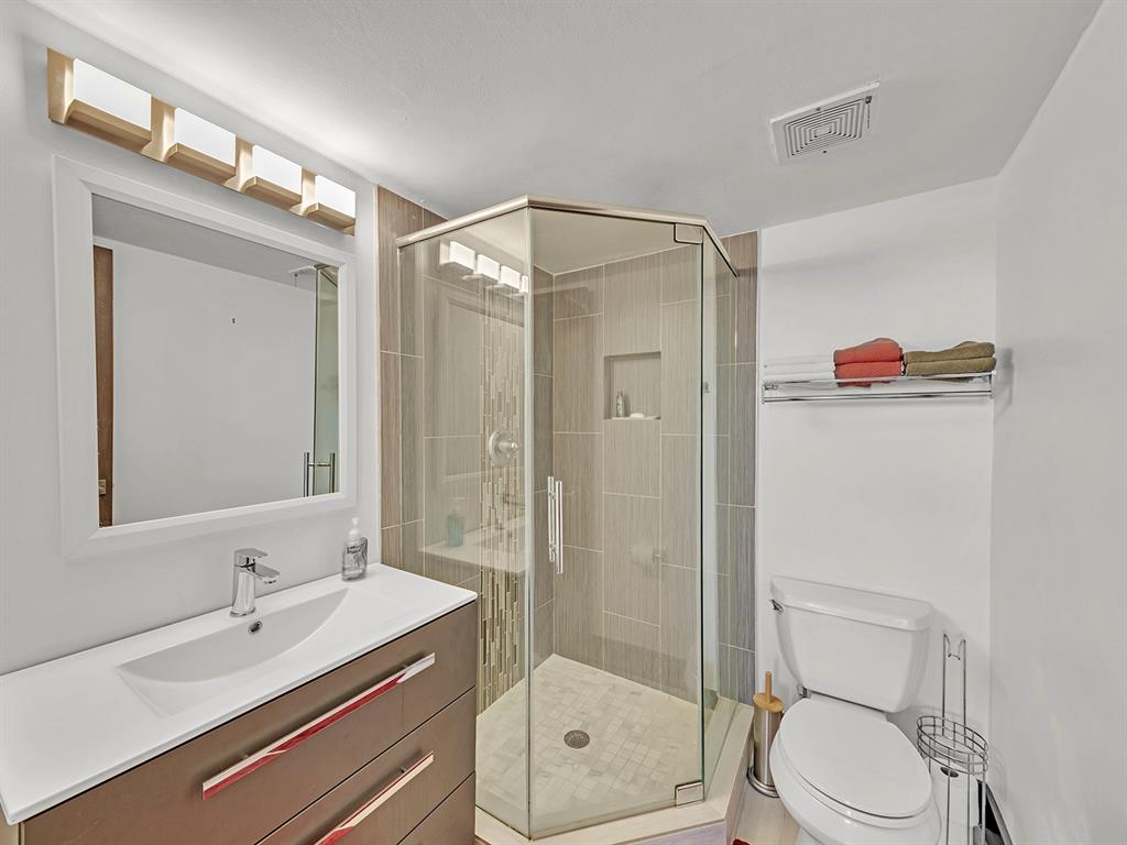 1421 South Ocean Boulevard, Unit 506 Pompano Beach, FL 33062 - Photo 19 of 36 a bathroom with a sink vanity mirror and toilet