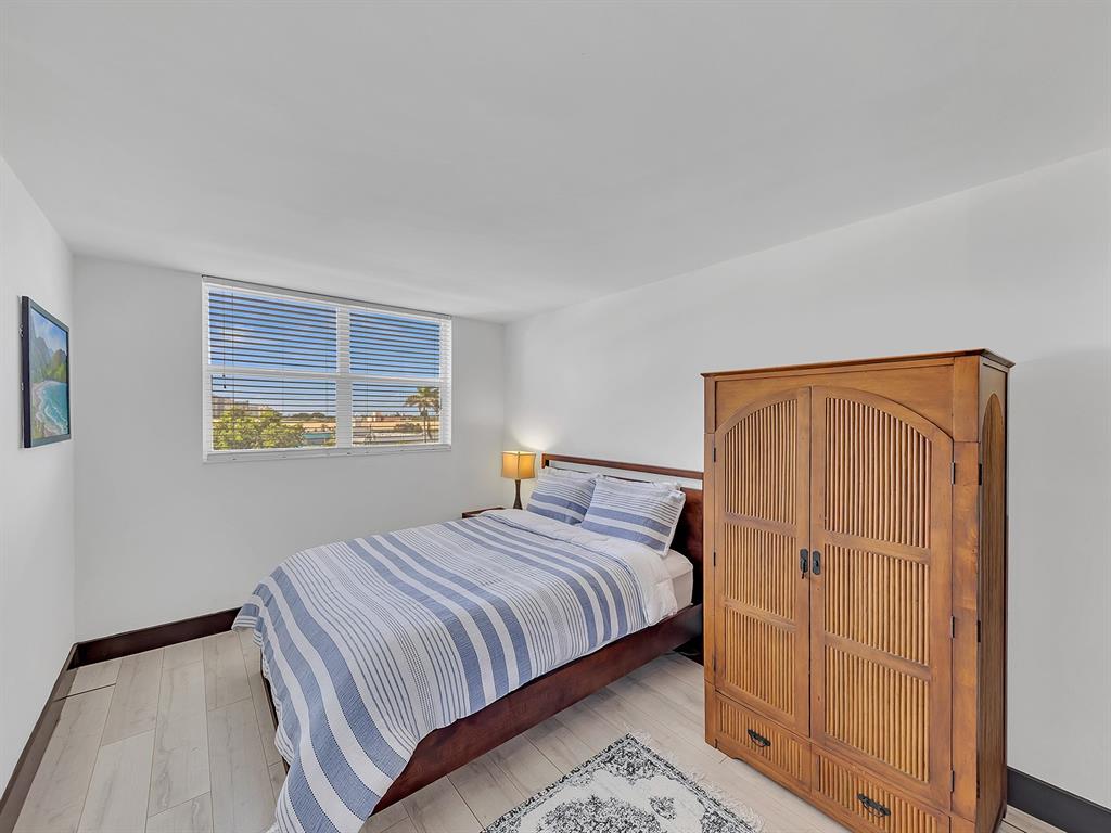 1421 South Ocean Boulevard, Unit 506 Pompano Beach, FL 33062 - Photo 21 of 36 a bedroom with a bed and cabinets