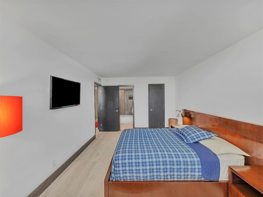 1421 South Ocean Boulevard, Unit 506 Pompano Beach, FL 33062 - Photo 26 of 36 a bedroom with a bed and a flat screen tv