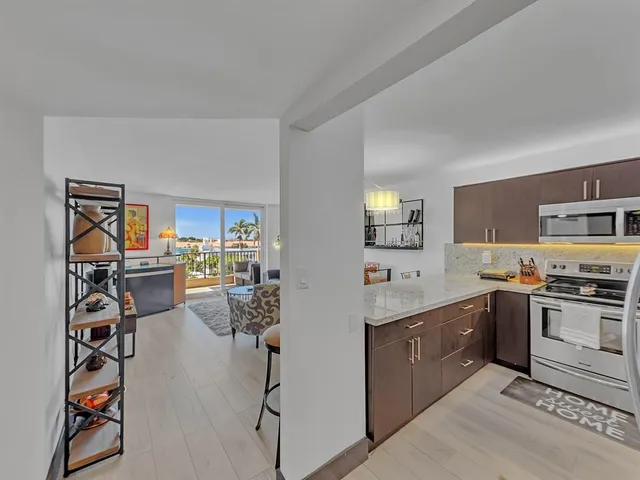 a large kitchen with stainless steel appliances granite countertop a refrigerator and a stove