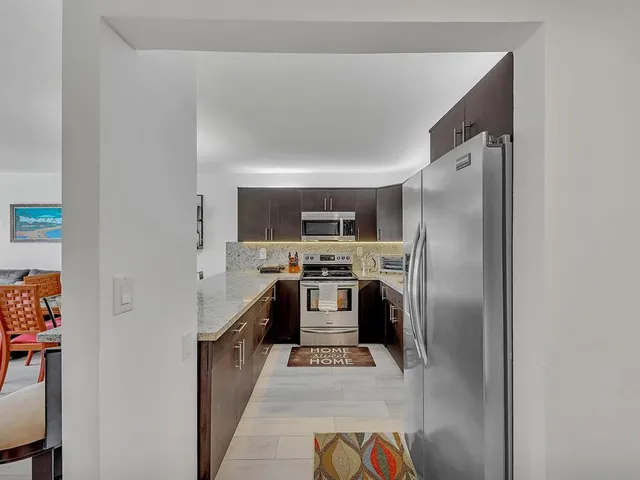 a kitchen with stainless steel appliances granite countertop white refrigerator a stove top oven a sink and dishwasher