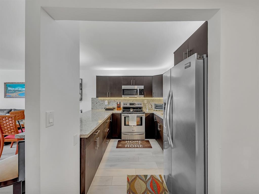 1421 South Ocean Boulevard, Unit 506 Pompano Beach, FL 33062 - Photo 5 of 36 a large kitchen with stainless steel appliances granite countertop a refrigerator and a stove