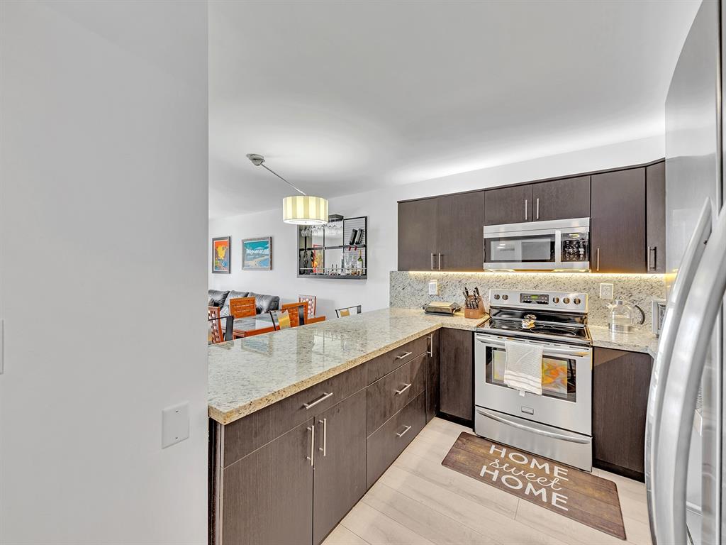 1421 South Ocean Boulevard, Unit 506 Pompano Beach, FL 33062 - Photo 7 of 36 a kitchen with stainless steel appliances granite countertop a stove a sink dishwasher and a refrigerator